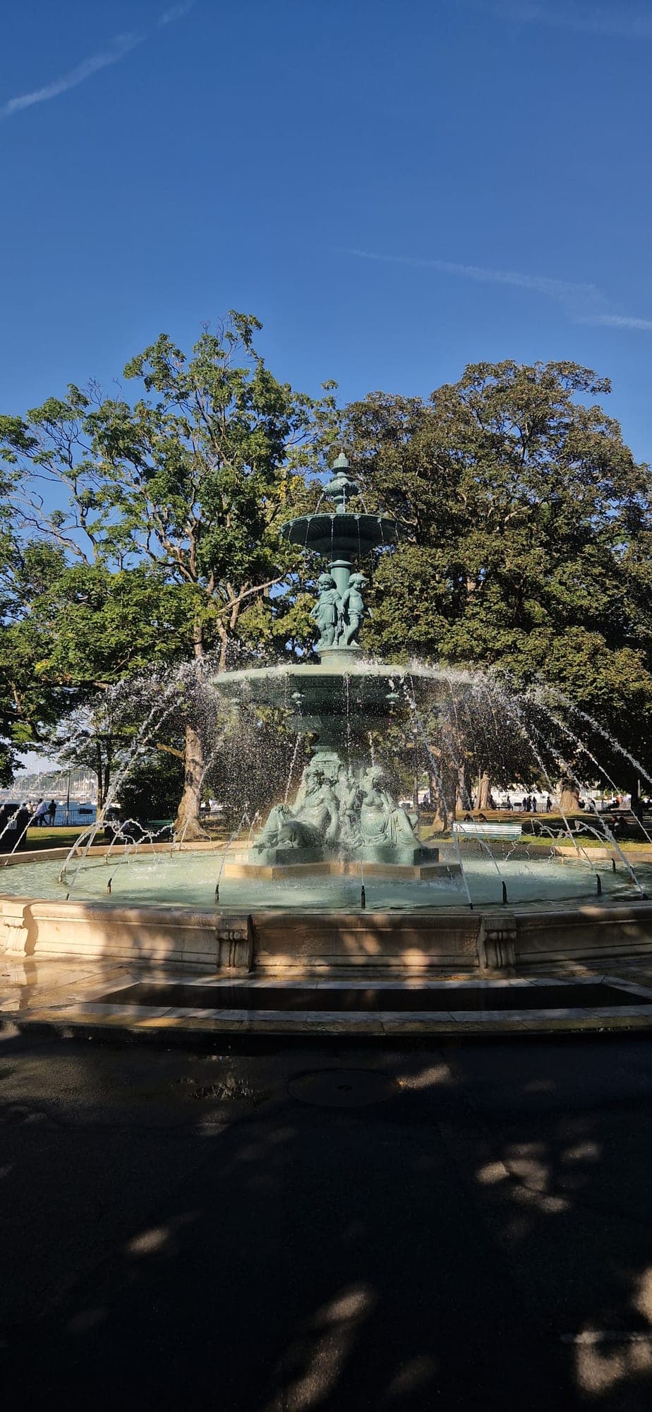 An ornate bronze fountain running in a Geneva park