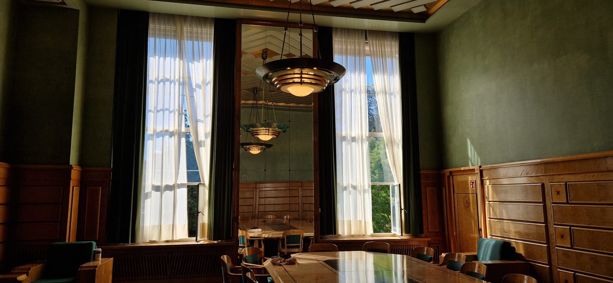 A panelled council room with tall windows inside the Palais des Nations